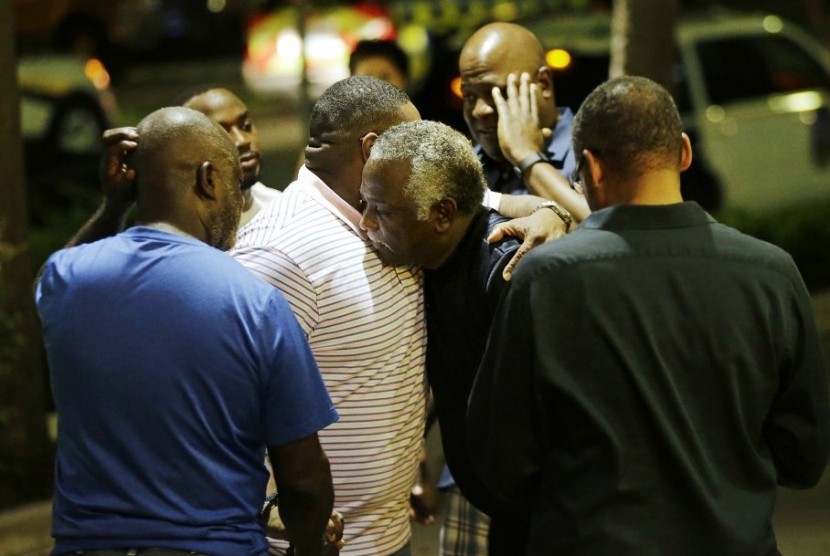 Sekelompok orang berdoa di seberang gereja Emanuel AME di Charleston, Rabu (17/6).