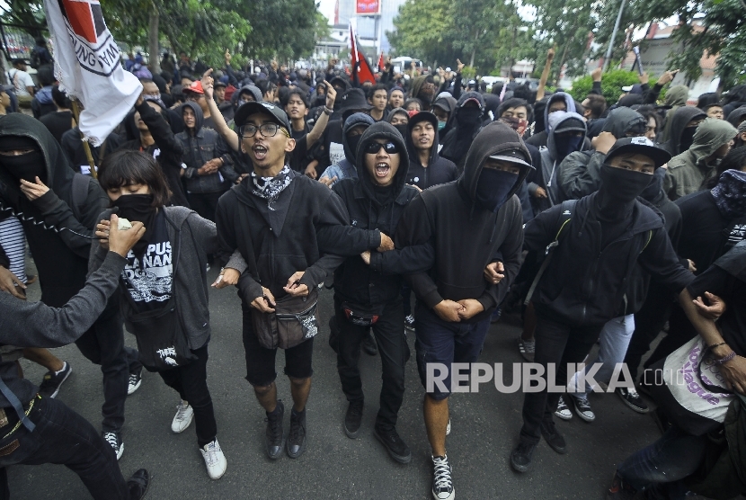 Sekelompok orang mengenakan baju hitam melakukan aksi dengan membakar spanduk dalam rangka may day di Jalan Gazebo, Kota Bandung, Senin (1/5)