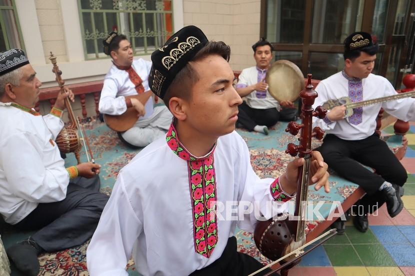 Sekelompok warga masyarakat dari etnis minoritas Muslim Uighur di Kota Aksu, Daerah Otonomi Xinjiang, China, memainkan alat musik tradisional, Kamis (22/4/2021), sebagai salah satu kegiatan rutin sore hari. Mereka memainkan alat musik untuk mengiringi para penari dari komunitasnya. 