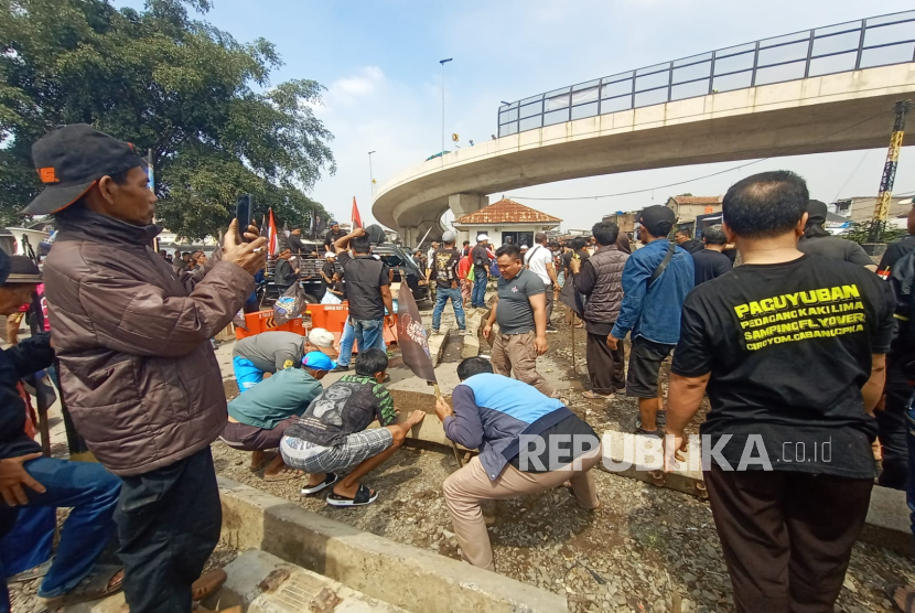 Sekelompok warga membuka paksa bantalan beton yang menutup perlintasan rel kereta api Ciroyom, Kota Bandung atau jalur perlintasan langsung 157, Senin (25/11/2024). Mereka mengeluh harus memutar untuk menuju ke pasar Ciroyom ditambah belum adanya jembatan penyeberangan orang (JPO). 