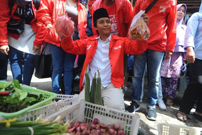 Sekretaris Dewan Pembina Partai Solidaritas Indonesia (PSI) Raja Juli Antoni menunjukkan sayur-mayur yang dibelinya di Pasar Kolpajung, Pamekasan, Jawa Timur, Jumat (1/2/2019). 
