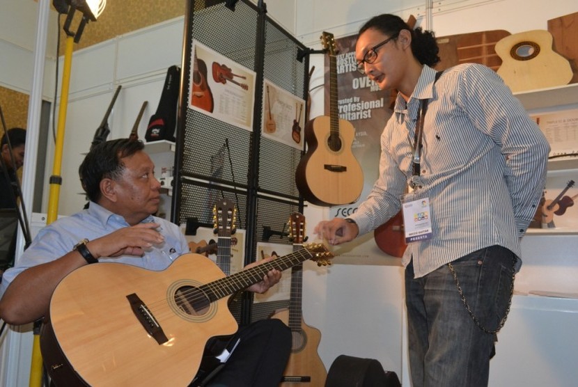 Sekjen Kemenperin Anshari Bukhari mencoba gitar Secco di Pameran Produk Indonesia (PPI), di Bandung, Ahad (29/9). 