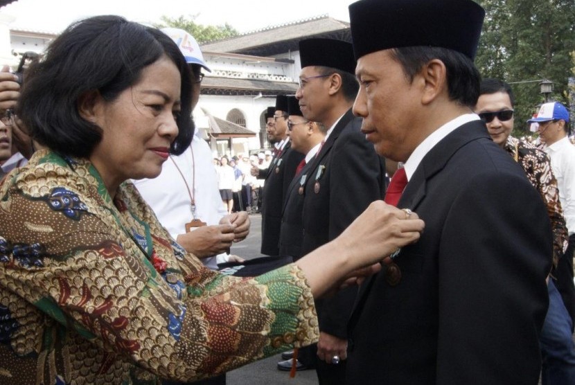 Sekjen Kementrian Kominfo Rosita Niken (kiri) memberikan penghargaan Satya Lencana Pembangunan serta Wira Karya kepada Direktur JNE Edi Santoso (kanan) di halaman Gedung Kantor Pusat PT Pos Indonesia (Persero), Jl Cilaki No 73 Bandung, Jumat (27/9).   