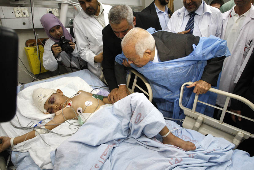  Sekjen Liga Arab Nabil Elaraby didampingi Perdana Menteri Palestina Ismail Haniyeh saat menjenguk seorang anak Palestina yang terluka dalam serangan udara Israel di sebuah rumah sakit di Gaza,Selasa (20/11). (AP Pool/Ahmed Zakot)