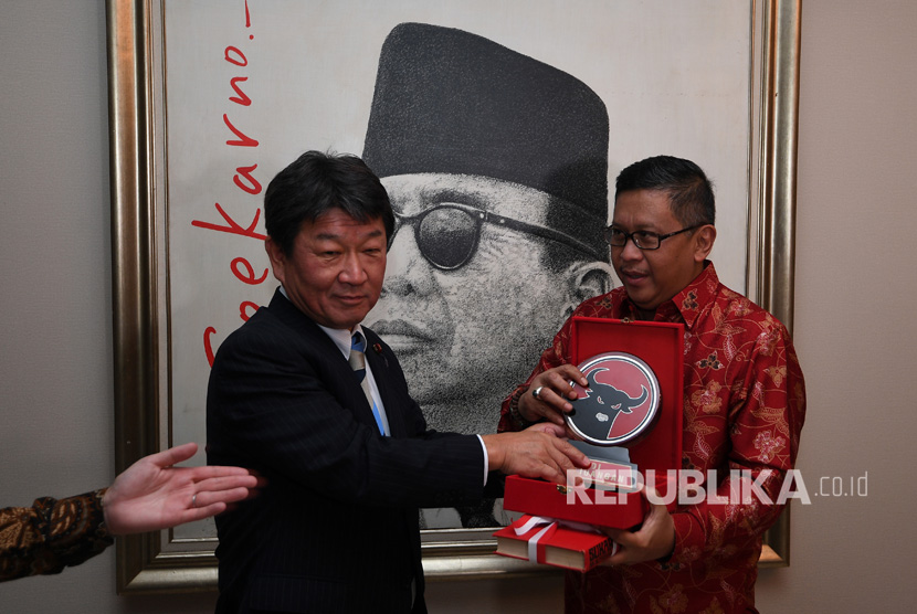 Sekjen PDI Perjuangan Hasto Kristiyanto (kanan) memberikan cinderamata kepada Ketua Dewan Riset Kebijakan Partai Demokrat Liberal Jepang Motegi Toshimitsu usai menerima kunjungannya di Kantor DPP PDI Perjuangan, Jakarta, Kamis (27/7)
