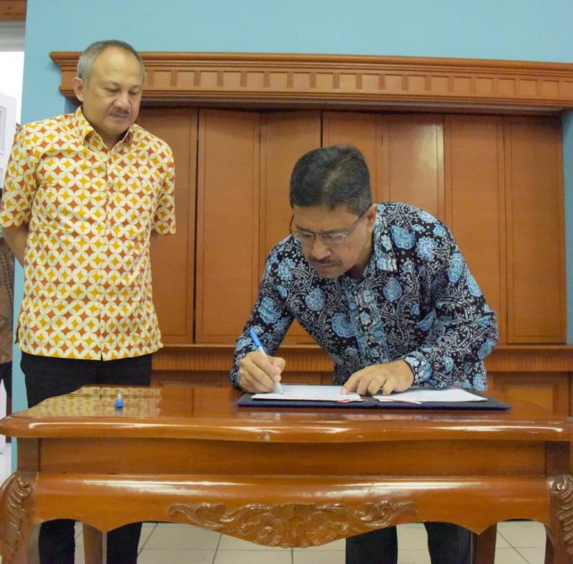 Sekretaris Daerah (Sekda) Provinsi Jabar Setiawan Wangsaatmaja (kiri) bersama Direktur Utama PT Pos Logistik Indonesia Yuzon Erman (kanan) menandatangani Mou dan PKS pendistribusian sejuta masker di Gedung Pakuan, Kota Bandung, Ahad (22/3).