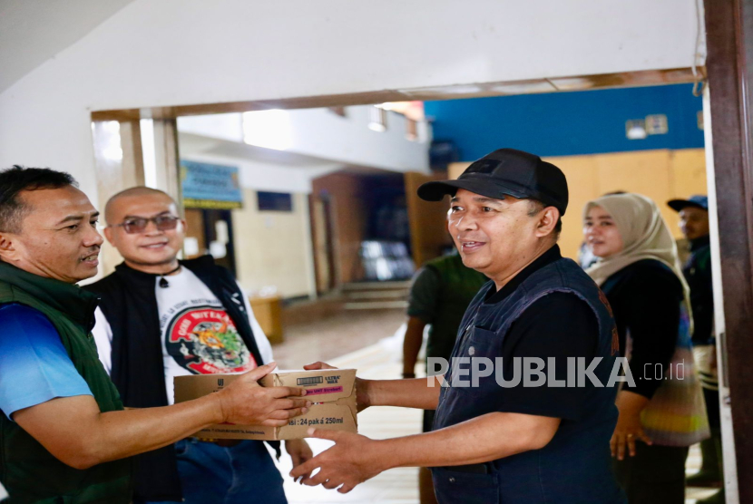 Sekretaris DPRD Provinsi Jawa Barat, Dodi Sukmayana (kanan) saat memberikan bantuan korban bencana alam di Rancamanyar, Kabupaten Bandung, Sabtu (6/12/25).