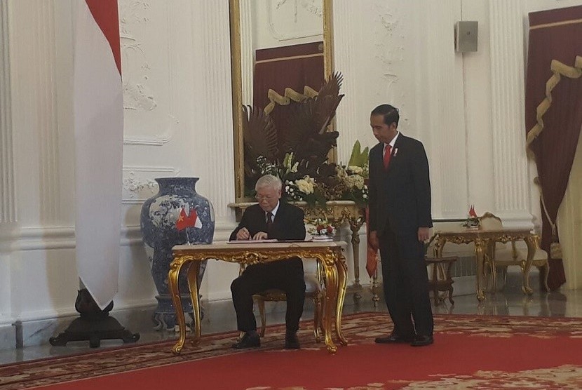 Sekretaris Jenderal (Sekjen) Partai Komunis Vietnam Nguyen Phu Trong (kiri) disaksikan Presiden RI Joko Widodo (kanan) menandatangani nota kesepahaman kerja sama bidang ekonomi dan hukum dengan Pemerintah Indonesia di Istana Negara, Jakarta, Rabu (23/8).