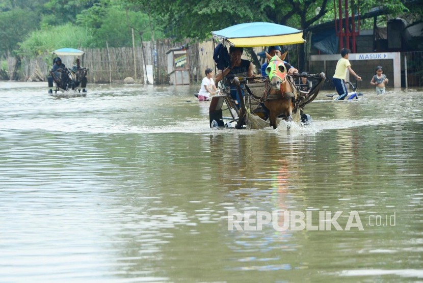 Selain perahu, untuk melewati jalan yang terendam banjir luapan Sungai Citarum, masyarakat menggunakan delman seperti di Cieunteung, Kecamatan Baleendah, Kabupaten Bandung, Senin (31/10). 