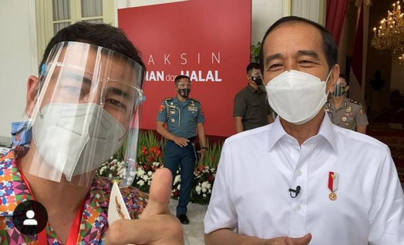 Selebritas Raffi Ahmad mengacungkan jempol saat berpose dengan Presiden Joko Widodo usai disuntik vaksin Covid-19 di Istana Kepresidenan, Jakarta, Rabu (13/1).