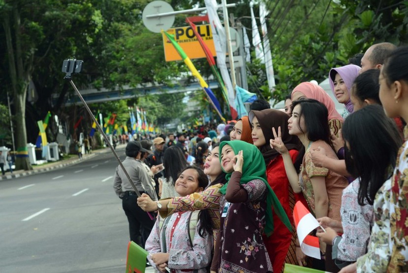 Selfie KAA: Sejumlah warga berselfie saat menunggu para delegasi dan para pejabat negara lewat menuju Konferensi Asia Afrika (KAA) ke-60, di Gedung Merdeka, Kota Bandung, Jumat (24/4). Momentum bersejarah tersebut diabadikan warga.  (Republika/Edi Yusuf)