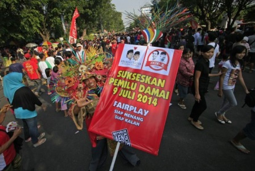 Seniman dari Republik Aeng-Aeng mengenakan kostum unik ketika mengkampanyekan pemilu damai pada Car Free Day di Solo, Jawa Tengah, Ahad (8/6). 