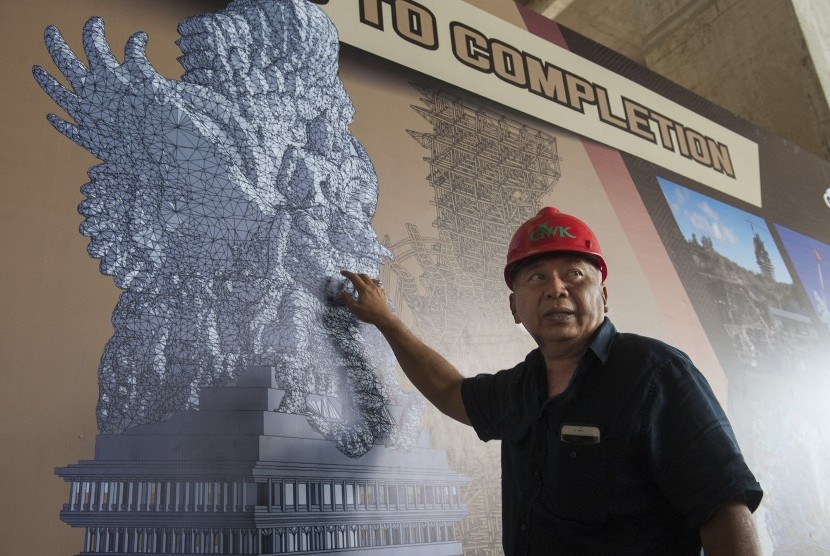 Seniman patung Nyoman Nuarta menjelaskan tahapan pemasangan bagian-bagian patung Garuda Wisnu Kencana di Bukit Jimbaran, Bali, Rabu (25/10).