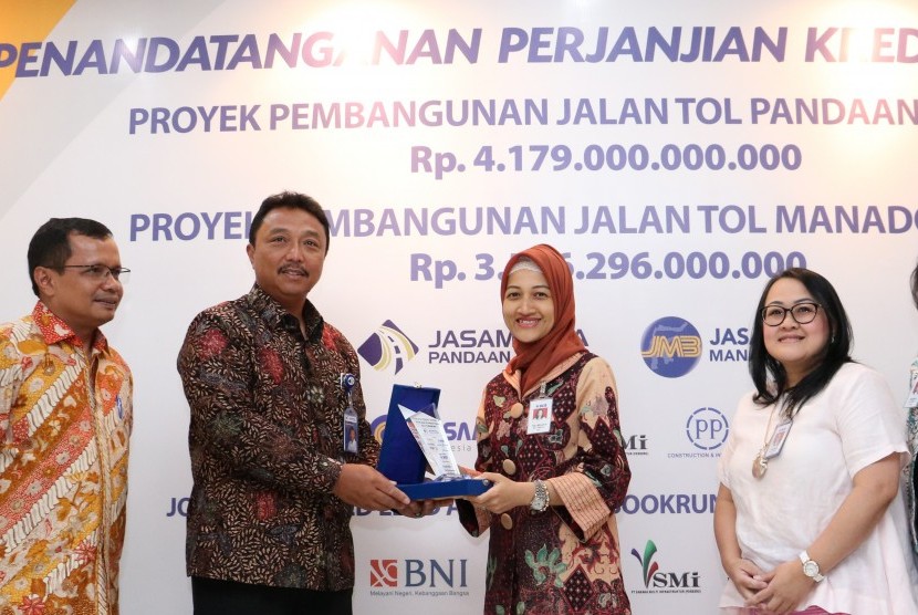 Senior Vice President Corporate Banking PT Bank Central Asia (BCA) Tbk Yuli Melati (ketiga kanan) bersama Senior Vice President Corporate Finance Susiana Santoso (kedua kanan) dan Senior Vice President Corporate Branch Dhejani Surjadi (kanan) menyerahkan cinderamata kepada Direktur Utama PT Jasamarga Pandaan Malang (JPM) Mohamad Agus Setiawan (ketiga kiri) disaksikan oleh Direktur Utama PT Jasamarga Manado Bitung (JMB) George IMP Manurung (kiri), Direktur Keuangan PT Jasa Marga Donny Arsal seusai penandatanganan dua Perjanjian Kredit Sindikasi di Jakarta, Jumat (13/10).