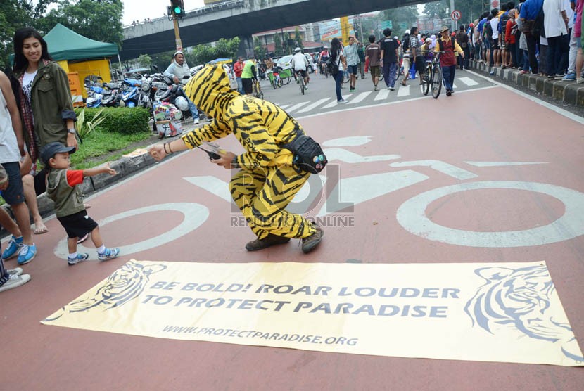  Seorang aktivis membagikan topeng harimau dalam aksi kampanye penyelamatan hutan Indonesia, di Car Free Day (CFD), Jl Ir H Djuanda, Kota Bandung.  (Ilustrasi) 