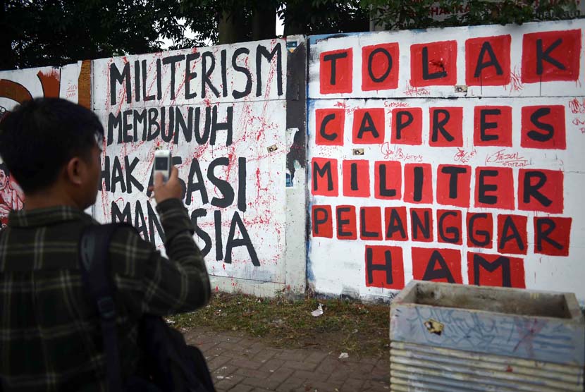 Seorang aktivis mengabadikan mural pelanggaran HAM ketika peresmian mural Prasasti Tragedi Trisaksti dan Mei 1998 di kawasan Jalan Pemuda, Jakarta Timur, Senin (12/5).
