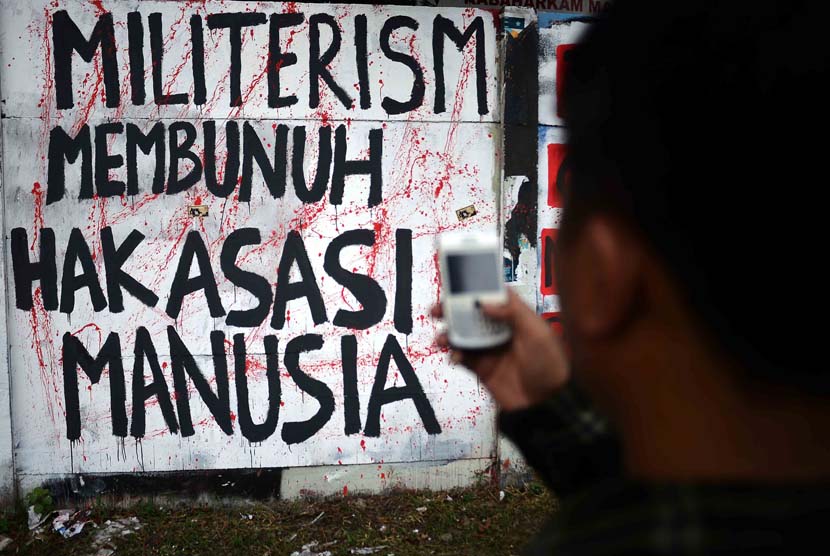 Seorang aktivis mengabadikan mural pelanggaran HAM ketika peresmian mural Prasasti Tragedi Trisaksti dan Mei 1998 di kawasan Jalan Pemuda, Jakarta Timur, Senin (12/5).