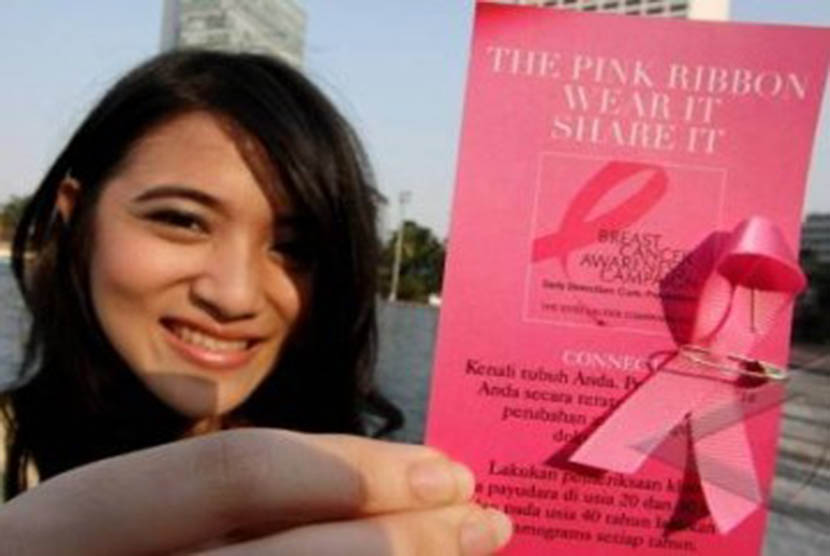 Seorang aktivis menunjukkan brosur pencegahan Kanker Payudara dengan pita berwarna merah Jambu saat kampanye Deteksi Dini Kanker Payudara di Bundaran Hotel Indonesia, Jakarta.