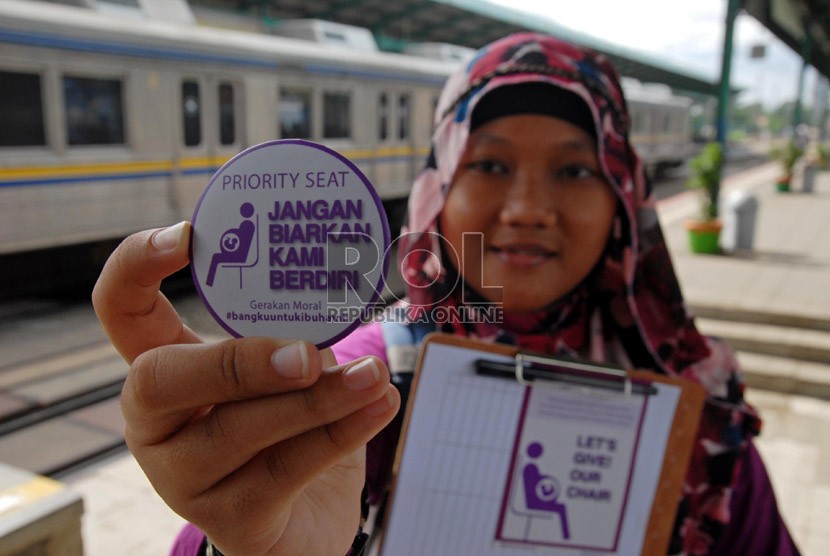  Seorang aktivis menunjukkan pin kampanye gerakan moral bangku untuk ibu hamil kepada pengguna jasa kereta api di Stasiun Manggarai, Jakarta Selatan, Rabu (26/12). (Republika/Agung Fatma Putra)