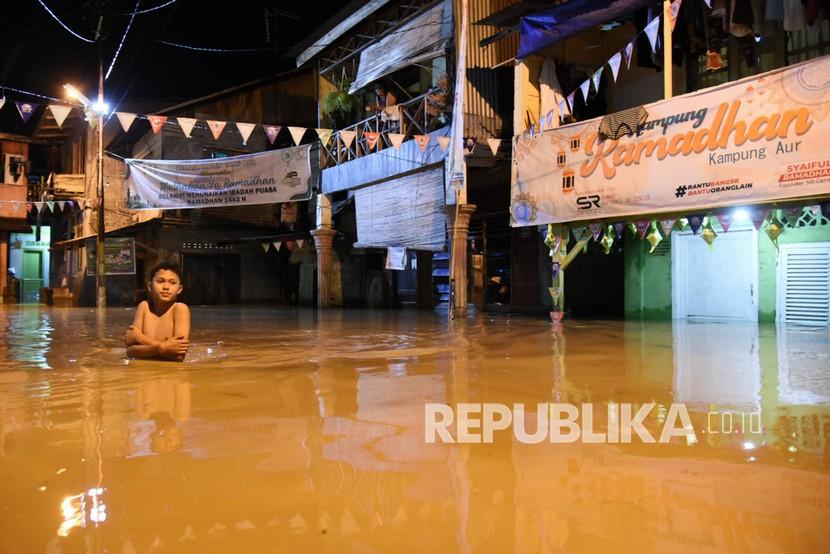 Seorang amelintasi banjir yang menggenangi pemukiman di kawasan Medan Maimun, Medan, Sumatera Utara. Pemkot Medan memasang pompa untuk mengatasi banjir di Pintu Tol Bandar Selamat.