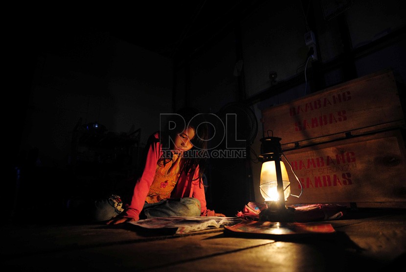   Seorang anak belajar dengan bantuan lampu penerangan di pemukiman transmigrasi di Desa Sebunga, Kecamatan Sajingan Besar, Sambas, Kalimantan Barat.  (Republika/Edwin Dwi Putranto)