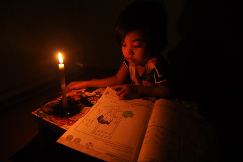 Seorang anak belajar dengan bantuan penerangan lilin saat terjadi pemadaman listrik di Palu, Sulawesi Tengah, Jumat (11/3). 