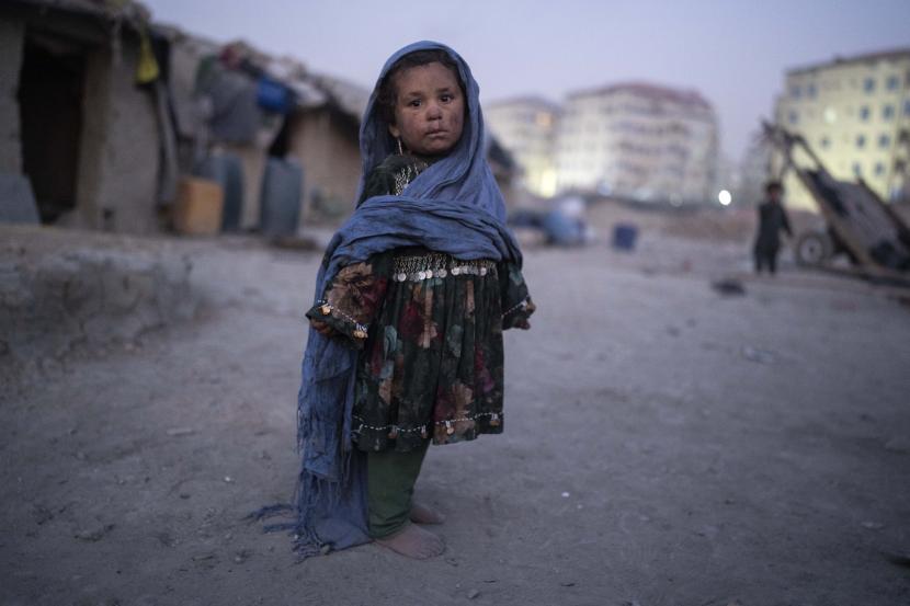 Arab Saudi Kirim Bantuan Kemanusiaan ke Afghanistan. Foto: Seorang anak berdiri di luar rumahnya di lingkungan tempat banyak pengungsi internal telah tinggal selama bertahun-tahun, di Kabul, Afghanistan, Selasa, 7 Desember 2021.