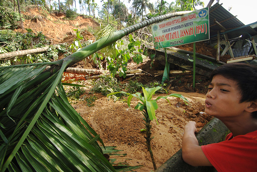 Seorang anak berkebutuhan khusus, berada di dekat sekolahnya yang tertimbun longsor, di Batugadang, Karangputih, Padang, Sumatera Barat, Kamis (12/11).