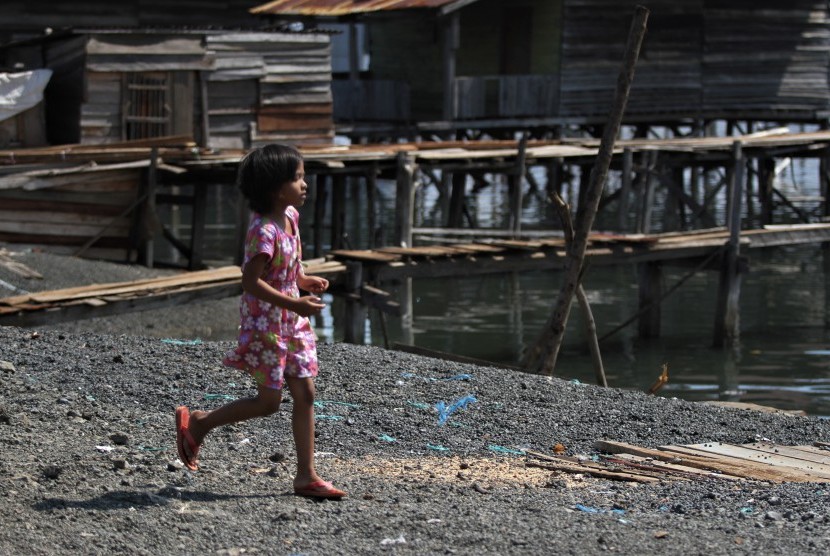 Seorang anak berlari diatas hambaran limbah butiran pembakaran Ore Nikel milik salah satu perusahaan pertambangan yang dibuang di pesisir laut di Kecamatan Pomalaa, Kabupaten Kolaka, Sulawesi Tenggara, Sabtu (18/5/2019).