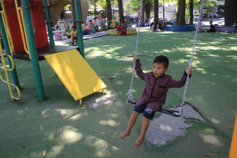 Seorang anak bermain ayunan di ruang terbuka hijau (ilustrasi)