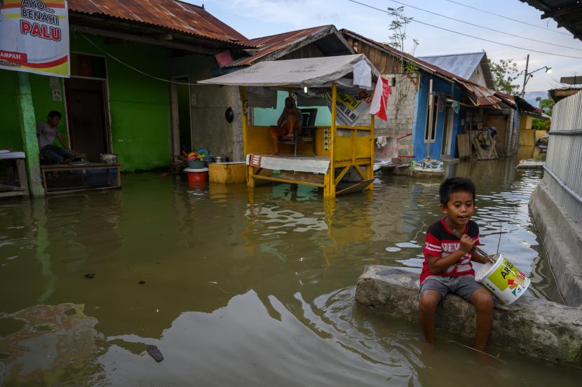 Seorang anak bermain di genangan air akibat banjir rob di Kampung Lere, Palu, Sulawesi Tengah, Sabtu (14/11/2020). Di pertengahan November 2021, BMKG mengingatkan warga Sulawesi Tengah mewaspadai hujan yang berpotensi banjir.