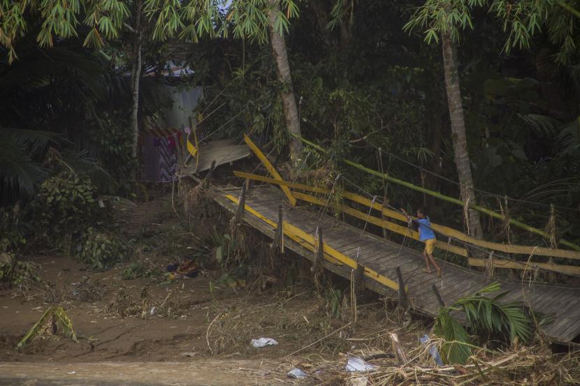 Dua Desa di Hulu Sungai Tengah Masih Terisolasi. Seorang anak bermain di jembatan rusak akibat banjir bandang di Desa Waki, Kabupaten Hulu Sungai Tengah, Kalimantan Selatan, Rabu (20/1/2021). Berdasarkan data Badan Penanggulangan Bencana Daerah (BPBD) Provinsi Kalimantan Selatan pada Rabu (20/1/2021) sebanyak 21 Jembatan, 110 tempat ibadah, 76 sekolah serta 18.294 meter jalan terdampak banjir dan longsor di Kalimantan Selatan. 