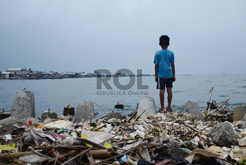 Seorang anak bermain di tumpukan sampah yang berada di Pesisir Pantai, Jakarta Utara, Kamis (29/1).(Republika/Raisan Al Farisi)