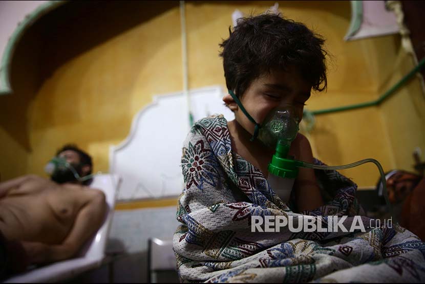 Seorang anak dan pria memperoleh penanganan medis setelah terpapar gas beracun di  Douma, Ghouta Timur, Damascus, Syria, pada 25 Februari 2018.