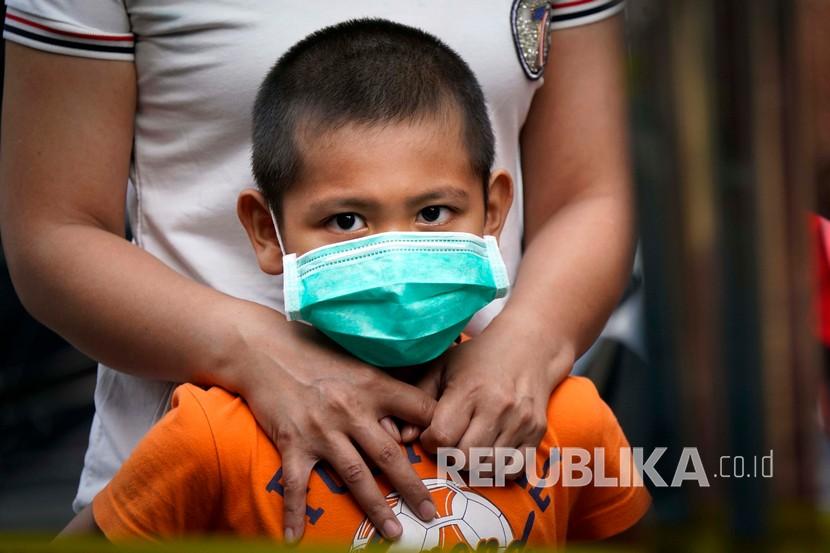 Seorang anak dengan menggunakan masker menunggu tes Covid-19 di Kampung Baru di Kuala Lumpur, Malaysia. Kementerian Kesehatan dan Kementerian Pendidikan Malaysia membahas kapan sekolah buka. Ilustrasi. 