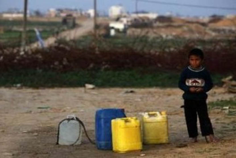 Seorang anak di Gaza dengan beberapa dirijen air yang kosong di sampingnya. ilustrasi