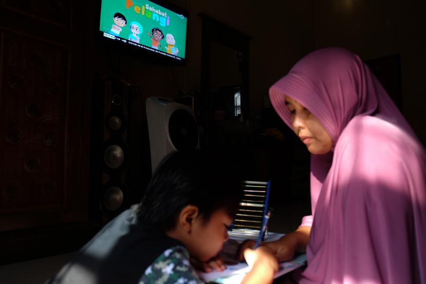 Seorang anak didampingi ibunya belajar dengan melihat tayangan siaran TVRI di rumah mereka, di Deli Serdang, Sumatra Utara, Senin (13/4/2020). Orang tua dan keluarga harus memahami literasi media dan digital pada masa adaptasi kebiasaan baru di tengah pandemi Covid-19 demi kelangsungan pendidikan anaknya.