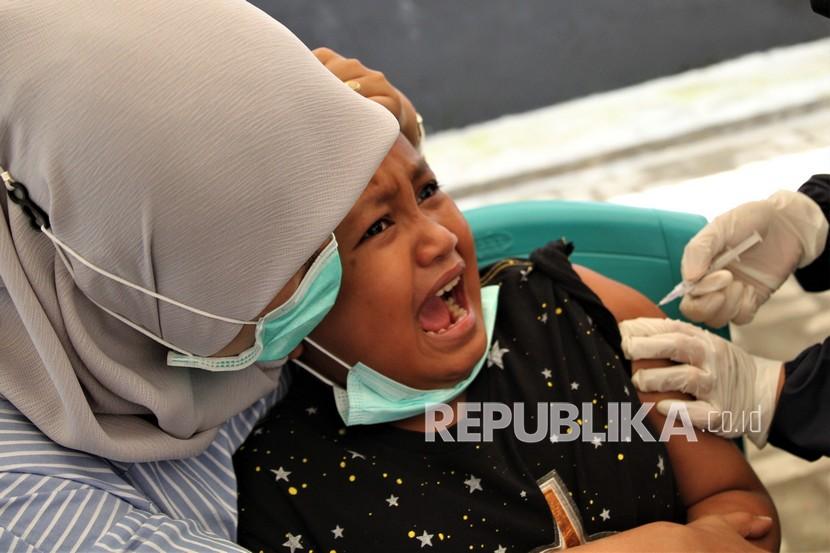 Seorang anak didekap ibunya saat diberi suntikan vaksin Covid-19 di Dinas Kesehatan Kota Kendari, Kendari, Sulawesi Tenggara, Selasa (15/2/2022). Anak usia di bawah enam tahun belum direkomendasikan untuk mendapat vaksin Covid-19.