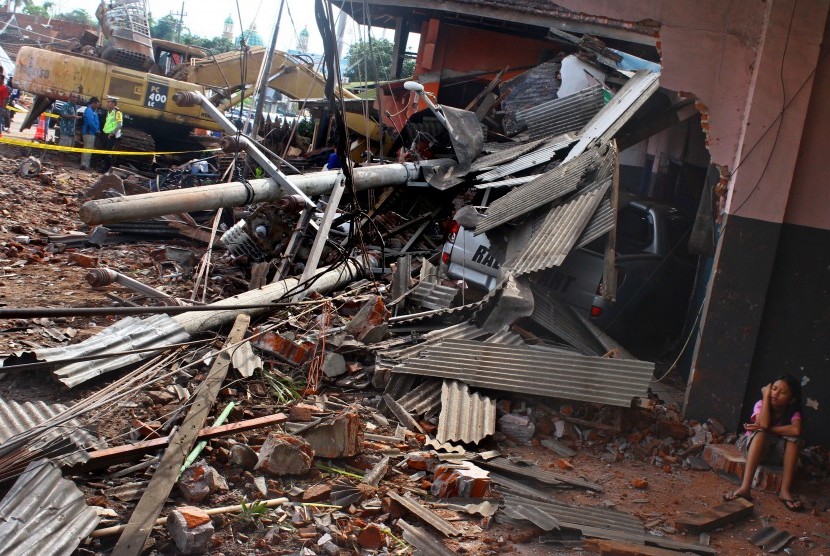 Seorang anak duduk di reruntuhan rumahnya yang hancur dalam akibat kecelakaan truk pengangkut alat berat di jalur Malang-Kediri, Junrejo, Batu, Jawa Timur, Selasa (26/12). 