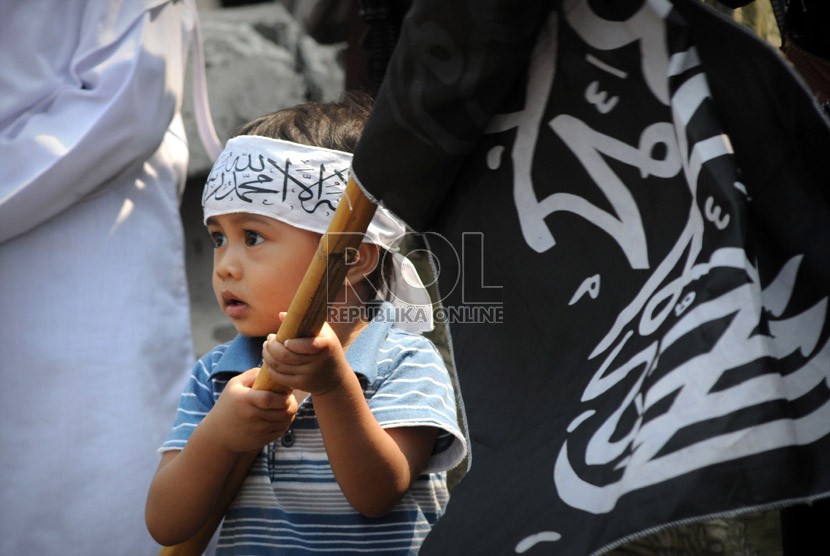   Seorang anak ikut bergabung dengan aksi unjuk rasa Hizbut Tahrir Indonesia yang mengutuk pembuatan film yang menghina Nabi Muhammad SAW di depan Kedubes Amerika Serikat, Jakarta, Jumat (14/9).    (Aditya Pradana Putra/Republika)