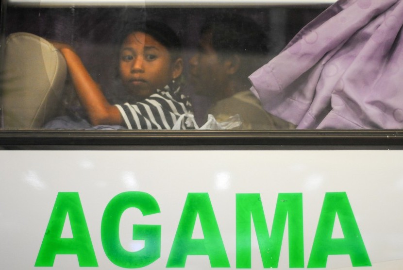 Seorang anak ikut bersama dalam bus yang mengangkut eks Gerakan Fajar Nusantara (Gafatar) saat tiba di Bandara Mutiara Sis Aljufri Palu, Sulawesi Tengah, Kamis (11/2) malam.