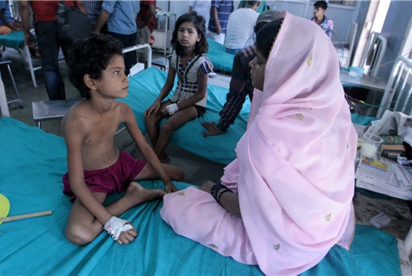 Seorang anak (kiri) ditemani ibunya menjalani perawatan di sebuah rumah sakit setelah mengalami keracunan makanan di Patna, Bihar, India. 