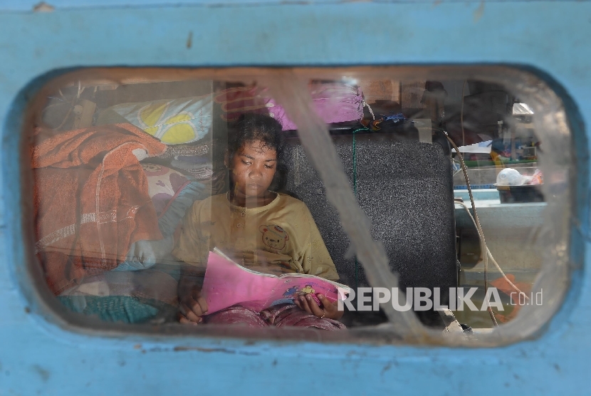 Seorang anak korban bongkaran pemukiman warga kawasan Pasar Ikan, Neneng (14) belajar di atas perahu, Penjaringan, Jakarta Utara, Jumat (15/4). (Republika/Raisan Al Farisi)