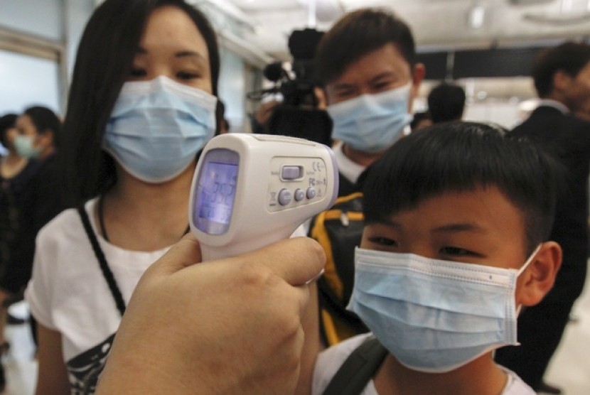Seorang anak laki diperiksa suhunya sebagai bentuk pencegahan MERS di Bandara Suvarnbhumi, Bangkok, Thailand, Ahad (21/6).