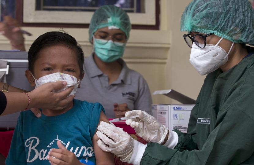 Seorang anak laki-laki bereaksi saat menerima suntikan vaksin Sinovac Covid-19 selama kampanye vaksinasi di sebuah sekolah dasar di Bali, pada Kamis, 23 Desember 2021. IDAI menyebut, KIPI pada anak bisa disebabkan karena anak ketakutan.