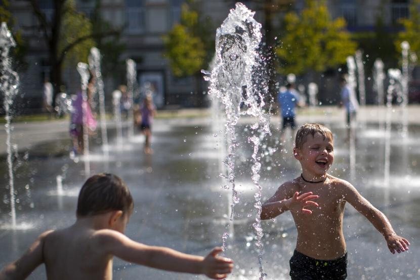 Seorang anak laki-laki melakukan pendinginan di air mancur umum di Vilnius, Lituania, Jumat, 22 Juli 2022. Suhu di Timur Tengah meningkat jauh lebih cepat daripada rata-rata dunia dalam tiga dekade terakhir. 