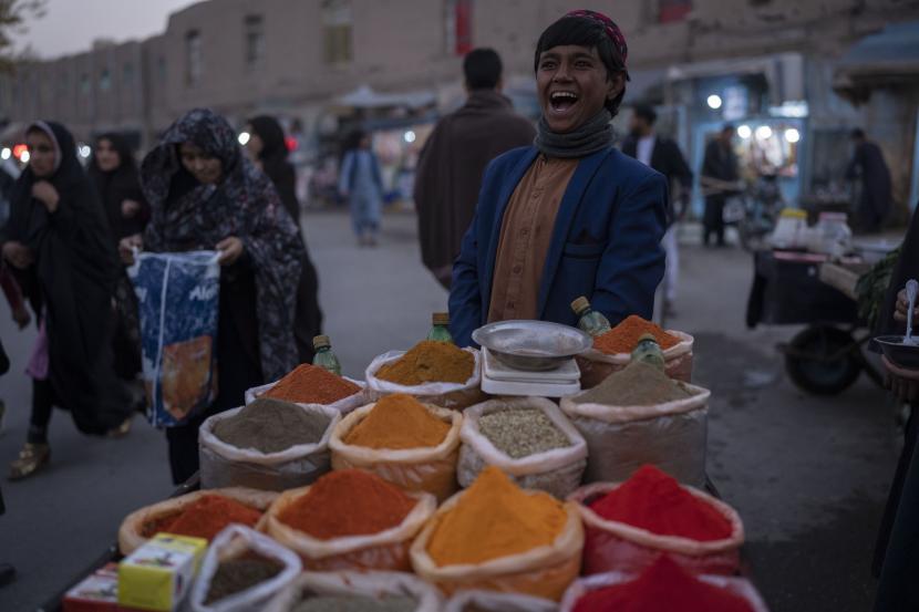 Ini Sikap Negara-Negara Islam dalam Krisis Afghanistan. Foto: Seorang anak laki-laki tertawa saat menjual rempah-rempah di pasar jalanan, di Herat, Afghanistan, Kamis, 25 November 2021
