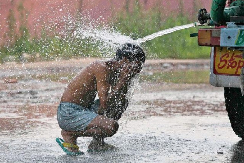 Seorang anak mandi di tengah suhu udara ekstrem yang mencapai 50 derajat Celsius di India sepekan terakhir.