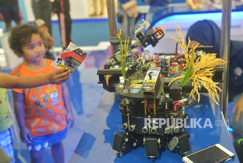 Seorang anak melihat robot penanam padi dalam Ritech Expo 2019 yaitu rangkaian peringatan Hari Kebangkitan Teknologi Nasional (Hakteknas) ke-24 di Denpasar, Bali, Ahad (25/8/2019).