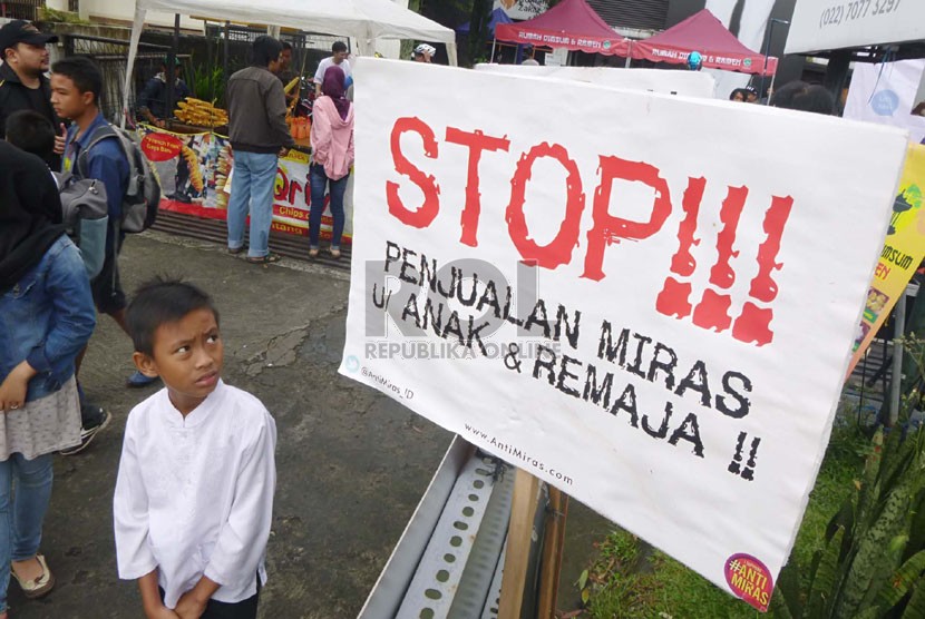 Seorang anak melihat sebuah poster antimiras pada aksi Gerakan Anti Miras (minuman keras) Nasional di Car Free Day (CFD) kawasan Dago, Bandung, Ahad (19/1). (Republika/Edi Yusuf)